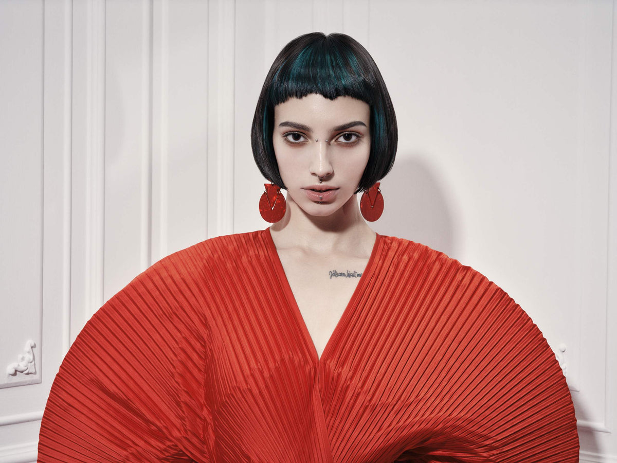 Modelo con bob negro brillante y blusa roja plisada, colección People 2026 de Framesi